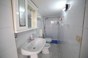 A bathroom with a sink, toilet, and shower.