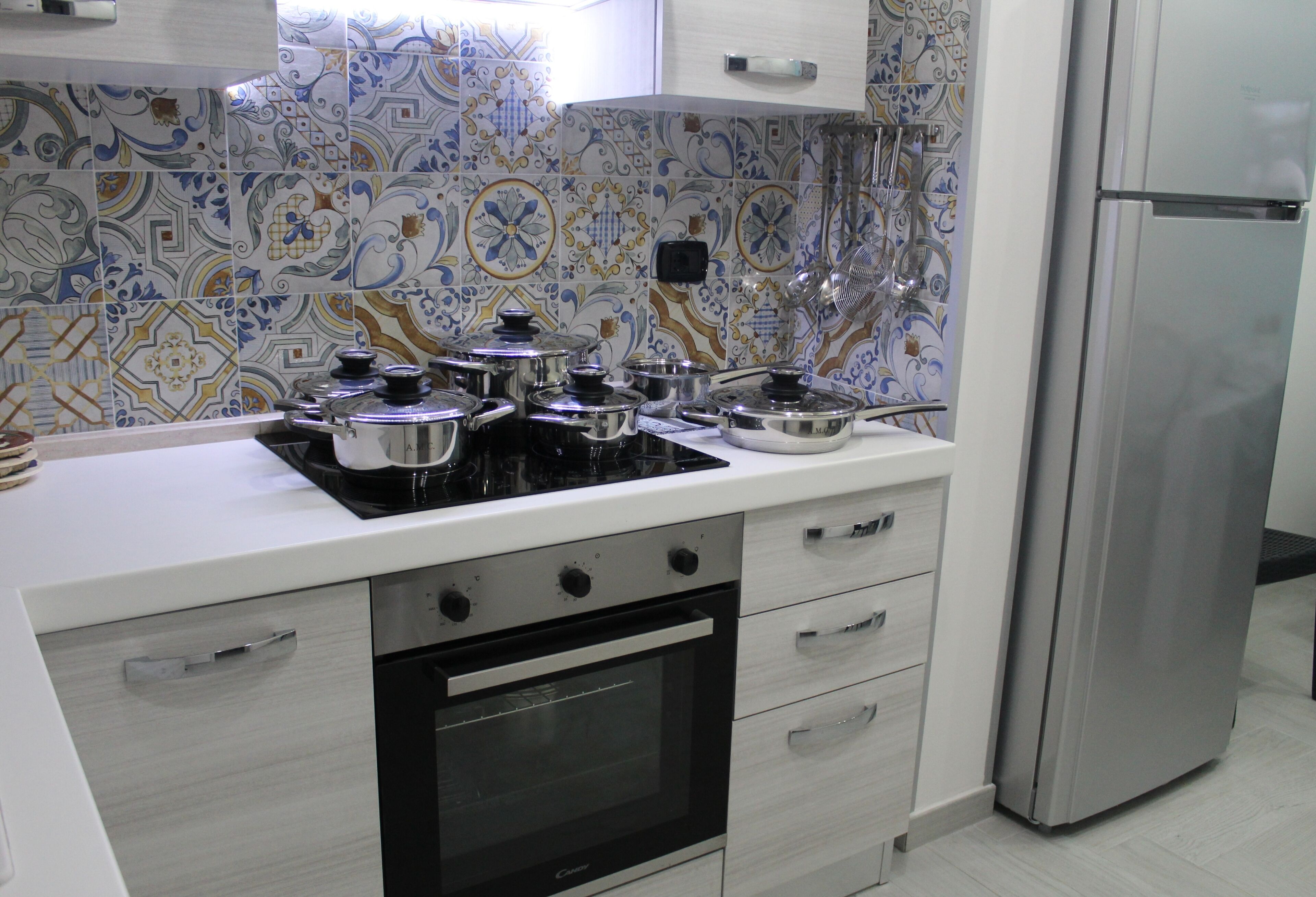 Uma cozinha moderna com fogão, forno e geladeira de aço inoxidável.