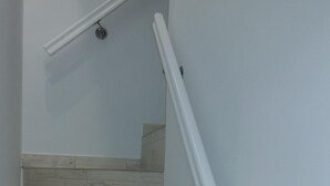 Una scala con gradini in legno e corrimano bianchi.