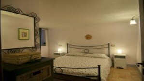 Een slaapkamer met een bed, nachtkastjes, een kast en een spiegel.