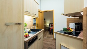 Una cucina compatta con mobili in legno, un lavandino e un fornello.