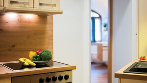 Una cucina con un fornello, una ciotola di frutta e un lavandino.
