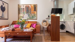 Un salon moderne avec un canapé, une table basse et un tableau accroché au mur.