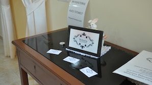 A reception desk with a sign reading "VICTORIA bed and breakfast," a white rabbit figurine, and a small candle. - Victoria (Ercolano)