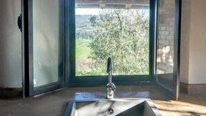Ein Badezimmer im Eckbereich mit Fenster, Waschbecken und Tür.