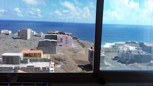 Vista costera con edificios y una carretera que lleva al mar.