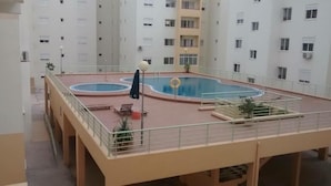 Zona de piscina en la azotea con piscina circular, un flotador salvavidas y un pequeño puente.