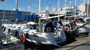 A marina with several boats docked, including one named 'GIOCONDA' with visible lifebuoys and ropes.