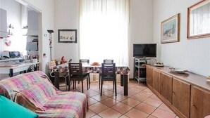 A compact living space with a dining area, a television, and a cabinet.