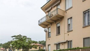 A multi-story building with balconies, large windows, and a flat roof.