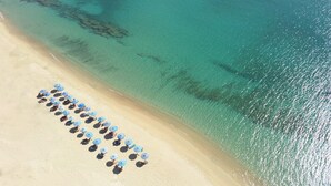 An aerial view of a beach with rows of umbrellas and sun loungers. - Seaside Naxos • 2 Villas • 7 Bedrooms / 7 Bath • Sleeps 18 @ Plaka Baech (Naxos)