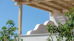 A wooden pergola structure with a white wall and a clear blue sky in the background. - Seaside Naxos • 2 Villas • 7 Bedrooms / 7 Bath • Sleeps 18 @ Plaka Baech (Naxos)