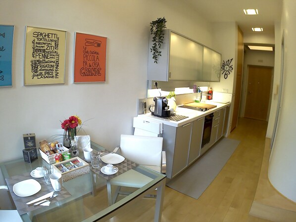 Enjoy cooking and dining in this inviting kitchen with a glass dining table, coffee machine, and ample counter space.