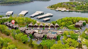 Ein Seehotel mit mehreren angestaubten Booten, einem Swimmingpool und traditionellen Holzhütten.