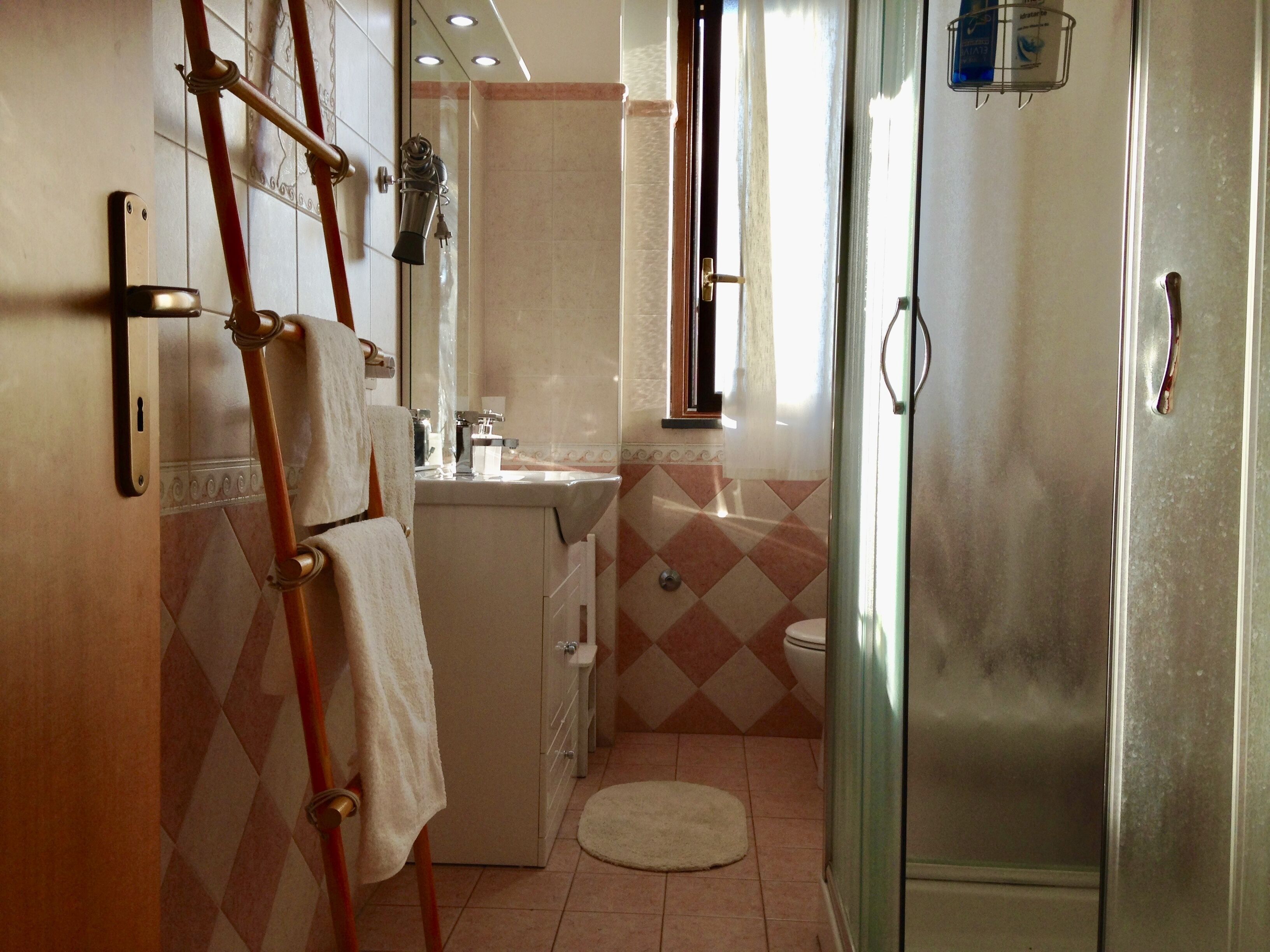 Une petite salle de bain comprenant une douche, des toilettes et un lavabo.