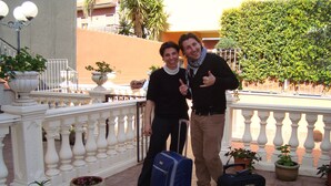 A balcony with white balustrades, potted plants, and a blue suitcase. - Apartment--close to Taormina, Etna, Catania, kitchen, parking, wifi,  (46)