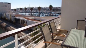 A balcony with a view of a marina, chairs, and a table. - Marina View apartment with personal WiFi & UK TV (Unknown)