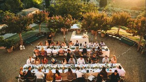 An outdoor dining area with multiple round tables set up for guests, surrounded by potted plants and trees. - Exclusive Villa 18th century, with pool. Fine winery in Chianti central Tuscany (Montevarchi Area)