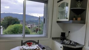 Une cuisine avec une fenêtre donnant sur un paysage montagneux.