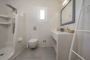 Ein modernes Badezimmer mit Toilette, Dusche und Waschbecken.