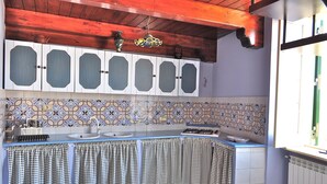 Una cocina con mantel a cuadros, salpicadero de azulejos y armarios de madera.