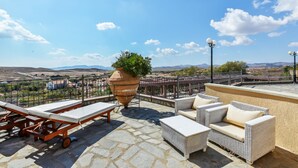 A rooftop terrace with lounge chairs, a large planter with greenery, and a view of distant hills. - Superior Suite with Sea View / Varos Village Boutique Hotel (Lemnos)