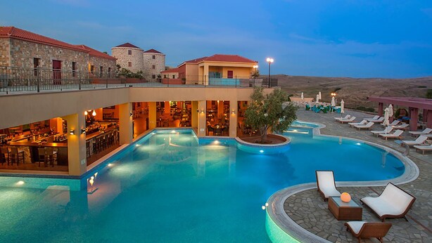 A resort with a swimming pool, lounge chairs, and a bar area. - Superior Suite with Sea View / Varos Village Boutique Hotel (Lemnos)
