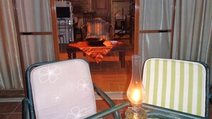 Comedor con una mesa dispuesta para dos, una silla con estampado floral y una lámpara de mesa.