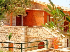 A stone building with a wooden facade, a stone staircase, and a metal railing.