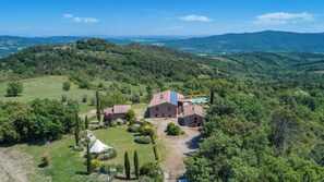 A rural property with a large stone barn, a swimming pool, and a well-maintained garden.