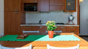 A modern kitchen with wooden cabinets, a built-in oven, and a gas stove.
