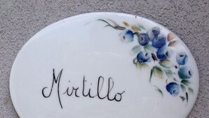A white ceramic plaque with the name "Mirillo" and a floral design.