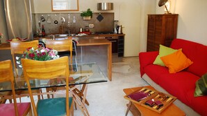 Ett kompakt bostadsutrymme med matplats, kök och sittgrupp.