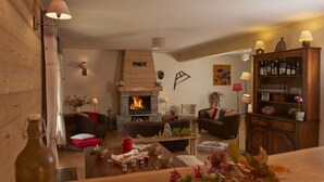 Una sala de estar acogedora con chimenea, muebles de madera y una estantería.