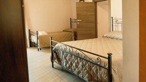 Un dormitorio con dos camas, techo de madera y un armario.