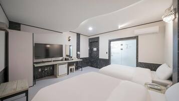 Une chambre d’hôtel moderne équipée d’un grand lit, d’une télévision, d’un bureau et d’une salle de bain.