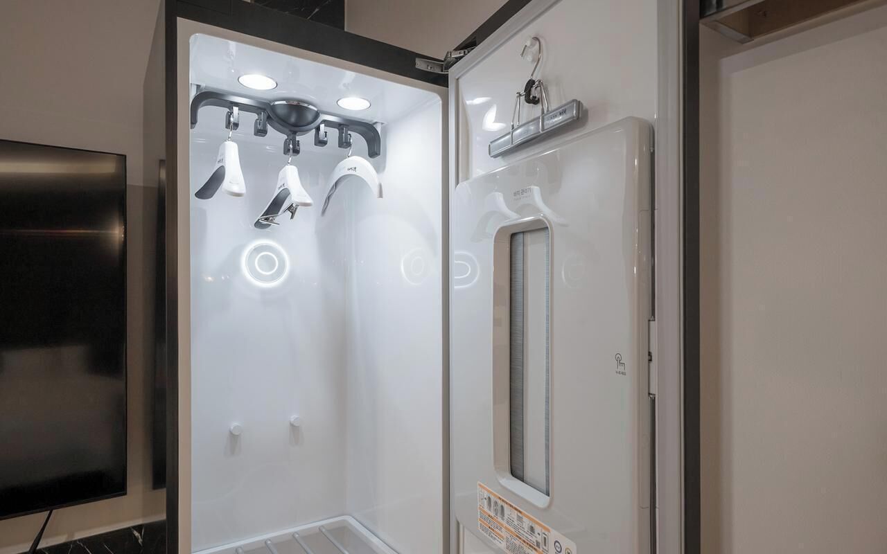 A bathroom with a shower, a mirror, and a television.