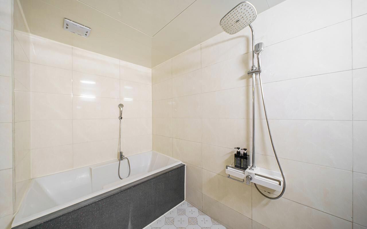 Un baño con bañera, ducha y grifo empotrado.