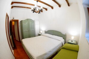 Una camera da letto con un letto grande, un comodino con una lampada, un armadio e un lampadario.