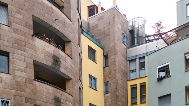 A multi-story building with balconies and a brick facade.