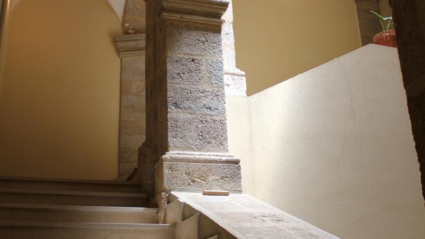Un escalier en pierre, orné d’arches, qui mène à un niveau supérieur.