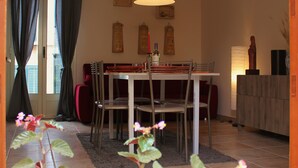 Un espace repas comprenant une table, des chaises et un luminaire suspendu.