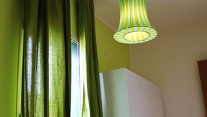 Une chambre à coucher avec un lit, une armoire et une lampe suspendue.