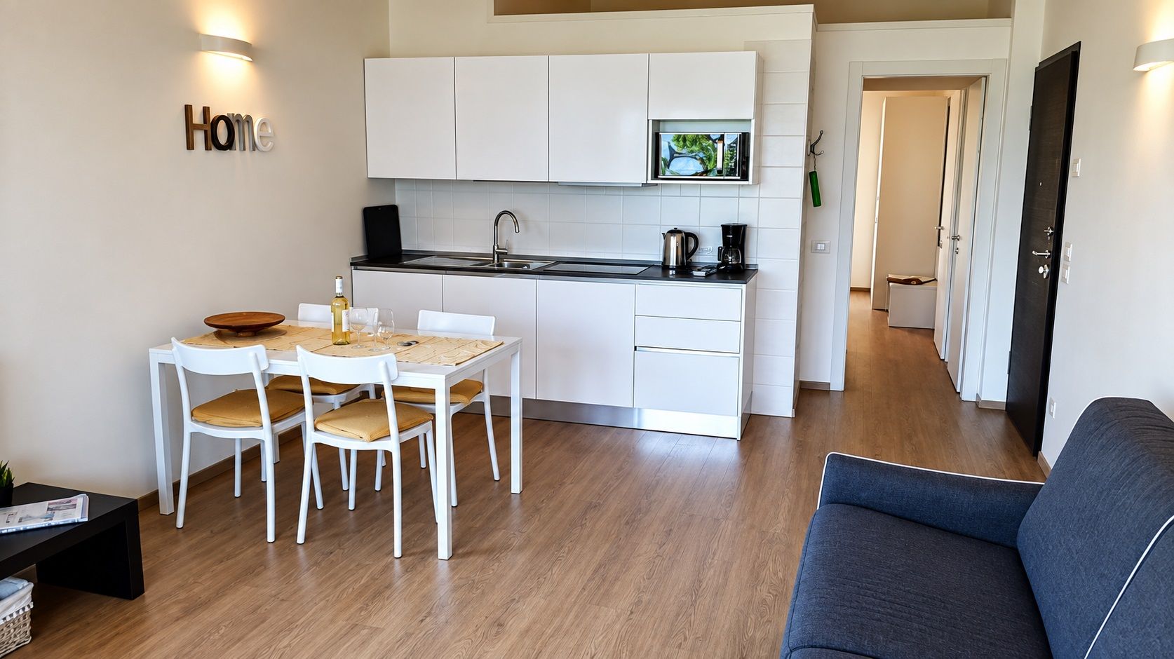 A compact living space with a dining area, kitchenette, and a sofa.