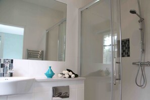 Habitación doble Deluxe, vista al jardín | Baño | Regadera, toallas, jabón, papel de baño
