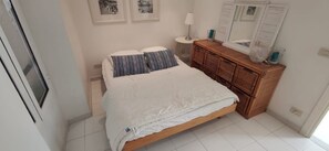 Quarto com cama, penteadeira e espelho.