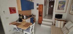 Um espaço compacto com cozinha compacta, área de refeições e espaço de estar.
