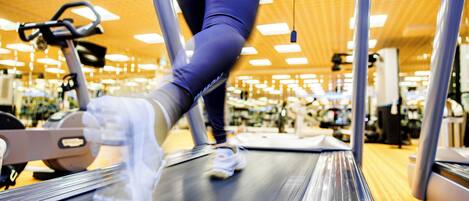 A treadmill in a gym with a person running.