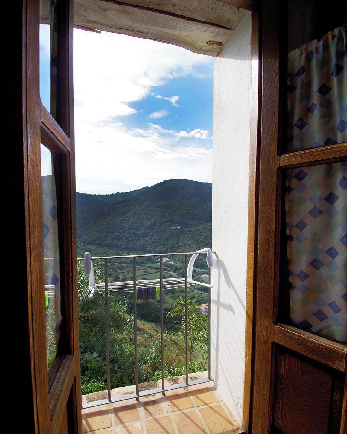 A balcony with a view of a mountainous landscape.
