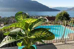 Een zwembad met uitzicht op een meer en bergen.